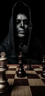 Hooded figure with chessboard in dark-themed wallpaper.