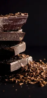 Pile of rich dark chocolate with shavings on a dark background.
