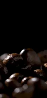 Close-up of shiny, dark coffee beans on black background.