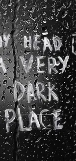 Rainy glass with black background and emotional quote.