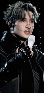 Futuristic performer in black with microphone.