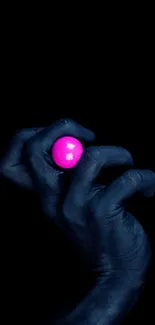 Dark blue hand holding a neon pink sphere in contrast.