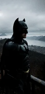 Dark hero standing by a scenic landscape with moody clouds.