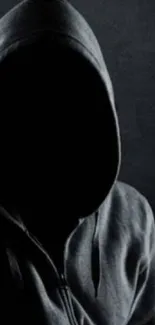 Dark hooded figure silhouette on dark background.