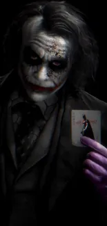 Joker holding a card in a dark setting.