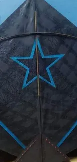 Dark kite with a star design and blue accents on a mobile wallpaper.