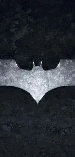 Dark metal bat emblem on black textured background.