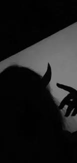 Dark silhouette of a figure with horns, evoking a mysterious aesthetic.