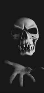 Dark skull extends a hand on a black background wallpaper.