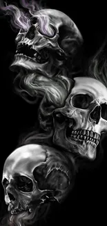 Three dark skulls with smoke on a black background wallpaper.