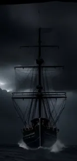 Ship sailing through a dark, stormy sea under an overcast night sky.