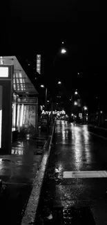 Black and white urban street at night with reflections.