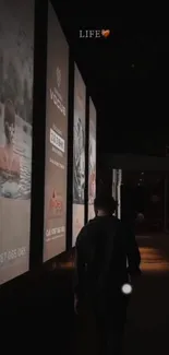 Dark urban street at night with illuminated billboards.