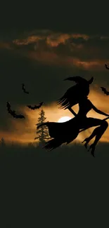 Silhouette of a witch on a broomstick with bats against a night sky.