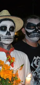 Dia de los Muertos festival attendees in skull makeup holding marigolds and candles.