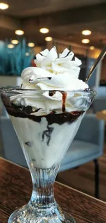 Ice cream sundae with chocolate and whipped cream in a glass cup.