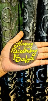 Hand holding a decorative birthday message with unique design.