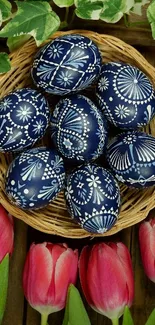 Blue decorated Easter eggs in a basket with tulips and leaves.