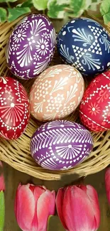 Colorful Easter eggs in a basket with tulips and leaves in the background.