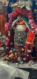 Decorative temple deity with flowers and offerings.