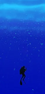 Silhouetted diver exploring a vast blue ocean with rising bubbles