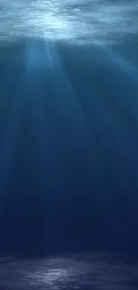 Serene deep blue ocean wallpaper with underwater light rays.