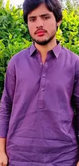 Person in deep purple attire with green foliage background.