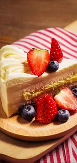 Slice of cream cake with strawberries and blueberries on a wooden plate.