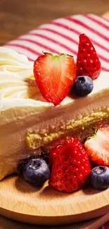 Slice of berry-topped cake on a wooden board with a striped cloth.