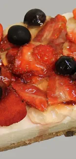 Sliced cheesecake with berries topping on gray background.