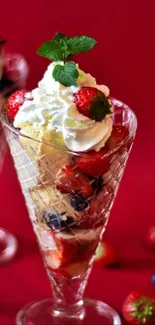 Berry dessert with cream in crystal glasses on red background.