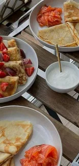 A delicious breakfast spread with crepes, strawberries, and smoked salmon.