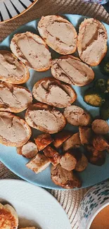 Breakfast spread on blue plate with bread, sprouts, sausages.