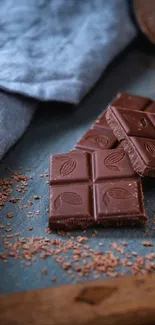 Rich dark chocolate pieces on rustic surface.