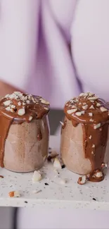 Chocolate desserts with nut topping on a tray.