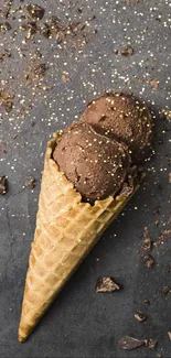 Chocolate ice cream cone with chocolate pieces on a rustic gray background.