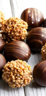 Chocolate truffles with nut topping on a rustic wooden surface.