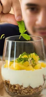 Person creating a vibrant dessert with fresh mint.