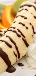 Banana dessert with chocolate drizzle and fruit on a plate.