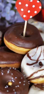 A tempting display of chocolate and white-iced donuts with floral and heart accents.