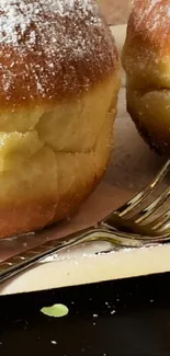 Close-up of a powdered doughnut with a fork on a stylish background.