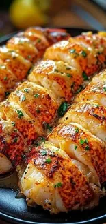 Close-up of grilled lobster tails garnished with herbs.