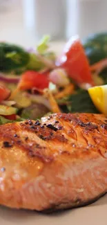 Grilled salmon with a vibrant salad of greens, tomatoes, and lemon slices.