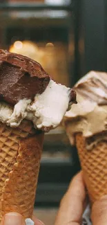 Two delicious ice cream cones held up in front of a café window, capturing a sweet moment.