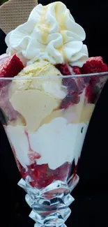 Ice cream sundae with strawberries and whipped cream in a glass dish.