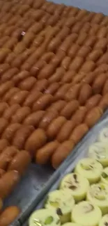 Tray of assorted Indian sweets featuring brown and yellow colors.