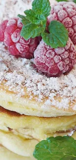 Fluffy pancakes topped with raspberries and sugar.