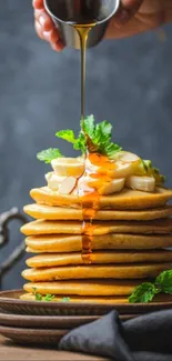 Stack of pancakes with syrup and bananas wallpaper.