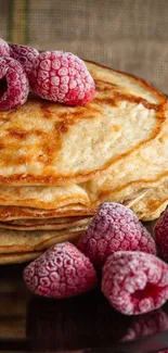 Stacked pancakes with frozen raspberries on top.