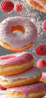 Pink glazed donuts with raspberries dropping gracefully.